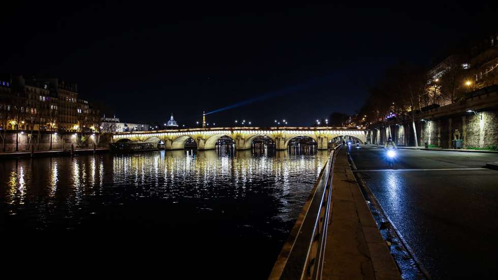 epa08886397 A man rides his bike at the banks of Seine river after the beginning of the curfew in Paris, France, 15 December 2020. Due to the still high number of Covid-19 cases, a curfew is imposed between 8 p.m. and 6 a.m. from 15 December 2020 on  EPA/MOHAMMED BADRA
