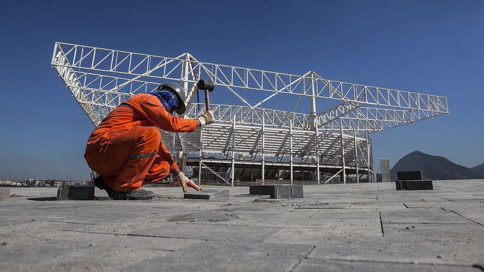 epa04794017 A worker is seen in front of the future Aquatic stadium, where the swimming competitions will take place during the Rio 2016 Olympic Games at Olympic Park of Barra da Tijuca in Rio de Janeiro, Brazil, 11 June 2015.  EPA/Antonio Lacerda