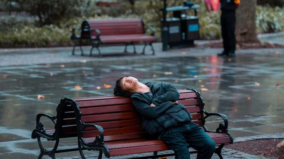 epa10861287 A man naps on a bench in a park, in Shanghai, China, 14 September 2023 (issued 15 September 2023). China's unemployment rate fell to 5.2 percent in August 2023, from 5.3 percent in July, according to a report from the National Bureau of Statistics. Last month, China suspended releasing the youth unemployment rate data after six consecutive increases. The National Bureau of Statistics reported the surveys need further optimisation and improvement.  EPA/ALEX PLAVEVSKI