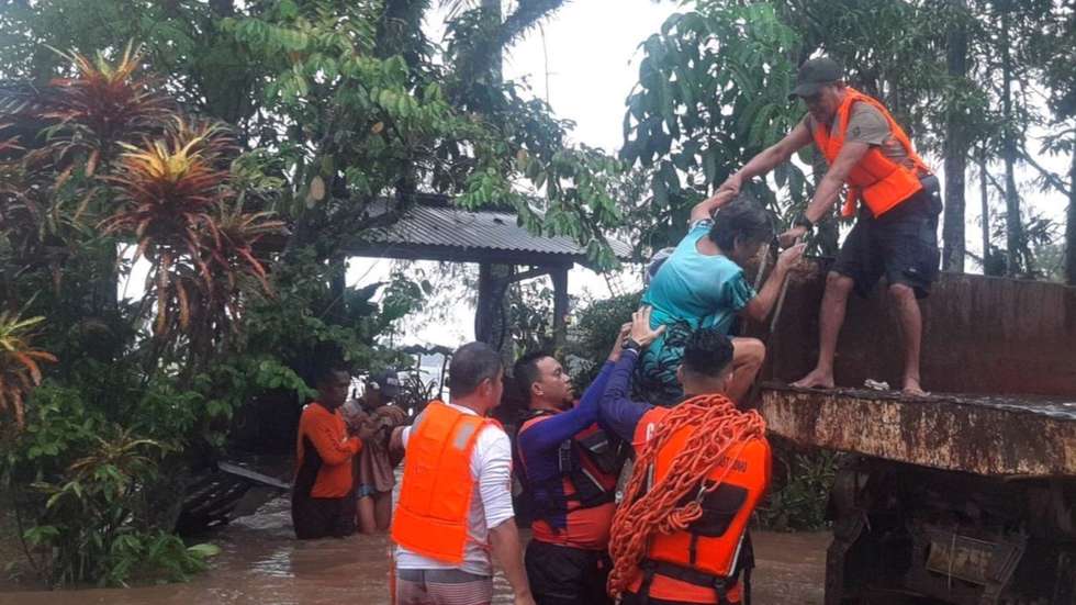 epa10379154 A handout photo made available by the Philippine Coast Guard (PCG) shows coast guard personnel assisting a resident during a rescue operation in the flood-hit town of Plaridel, Misamis Occidental province, Philippines, 26 December 2022 (issued 27 December 2022). At least eight people were reported dead and scores missing in Misamis Occidental due to flash floods brought by a weather occurrence called 'Shear line' affecting a wide area of southern Philippines.  EPA/PHILIPPINE COAST GUARD HANDOUT -- BEST QUALITY AVAILABLE -- HANDOUT EDITORIAL USE ONLY/NO SALES