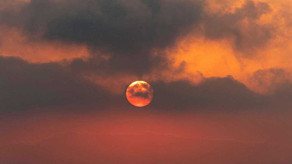 epa09630949 Dark clouds of ashes are seen at sunset as lava continues to flow from the Cumbre Vieja volcano in La Palma, Canary Islands, Spain, late 08 December 2021 (issued 09 December 2021). The volcano continues to be active since it's eruption started 19 September 2021.  EPA/Miguel Calero