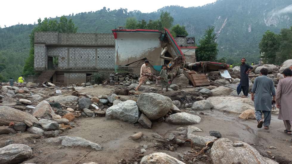 epa12306801 People survey the damages after flash floods in Buner, KPK province, Pakistan, 17 August 2025. Heavy rains and cloudbursts followed by flash-floods in northern Pakistan killed at least 300 people, while at least 150 are still missing, as authorities were still struggling to provide relief goods to the affected regions, according to The National Disaster Management Authority (NDMA).  EPA/STRINGER