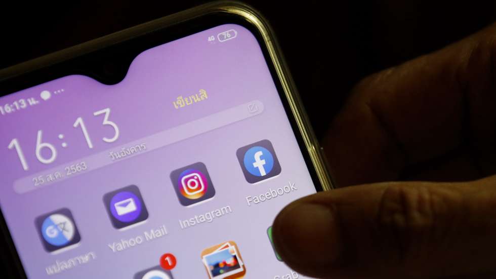epa08624241 A Facebook application icon (R) is seen on a mobile phone in Bangkok, Thailand, 25 August 2020. Facebook announced preparations for legal action against the Thai government after it demanded the social media platform to block users within Thailand to access the one million members of the 'Royalist Marketplace' Facebook group alleged of critical the king. The 'Royalist Marketplace' Facebook group was created by a Thai self-exiled academic and monarchy critic, Pavin Chachavalpongpun who is currently working as an associate professor in Japan.  EPA/RUNGROJ YONGRIT