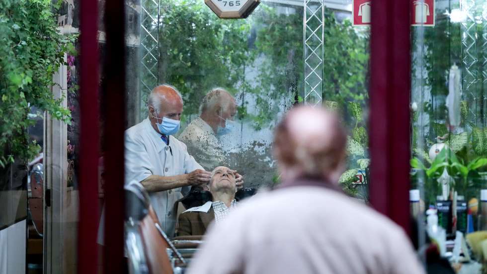 Barbeiro no centro do Porto corta o cabelo no primeiro dia da reabertura do comercio tradicional, Porto, 04 de maio de 2020. Com o fim do estado de emergência, algumas lojas do centro histórico do Porto já reabriram, seguindo algumas normas de segurança, impostas tanto para para funcionários como para clientes. ESTELA SILVA/LUSA