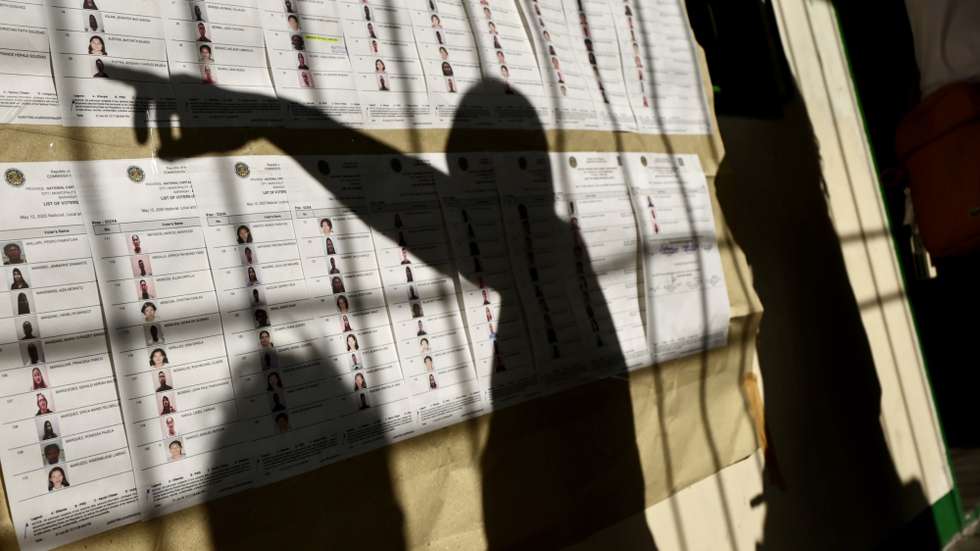 epaselect epa12092855 Filipinos look for their names on charts to cast their election ballots at a school used as a polling station in  Muntinlupa city, Metro Manila, Philippines, 12 May 2025. Filipinos trooped to polling stations to cast their votes for the 12 May national and local mid-term elections, with approximately 18,000 government positions, ranging from senators to local village officers, expected to be filled.  EPA/FRANCIS R. MALASIG