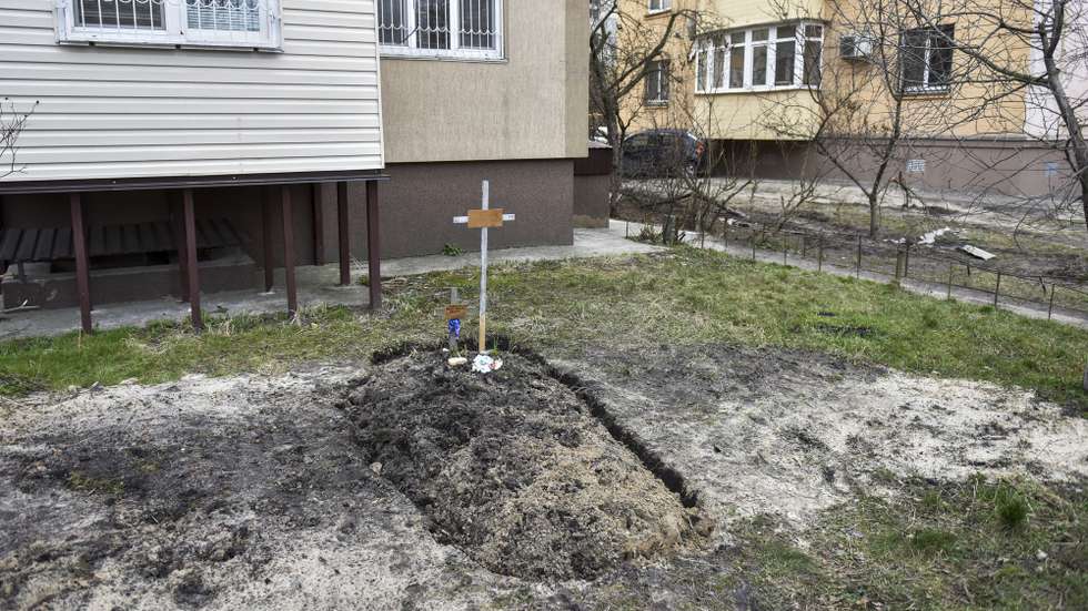 epa09870783 Graves are seen in front of a residential building in Bucha city, which was the recaptured by the Ukrainian army, Kyiv (Kiev) area, Ukraine, 04 April 2022. More than 410 bodies of killed civilians were carried from the recaptured territory in Kyiv's area for exgumation and expert examination. The UN Human Rights Council has decided to launch an investigation into the violations committed after Russia's full-scale invasion of Ukraine as Ukrainian Parliament reported. On 24 February, Russian troops had entered Ukrainian territory in what the Russian president declared a 'special military operation', resulting in fighting and destruction in the country, a huge flow of refugees, and multiple sanctions against Russia.  EPA/OLEG PETRASYUK ATTENTION: GRAPHIC CONTENT