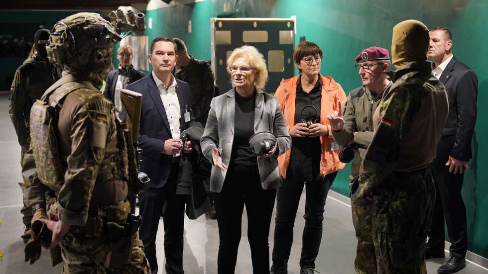 epa10262499 German Minister of Defense Christine Lambrecht (C) speaks with soldiers at a shooting range during her visit to the German Special Forces Command (KSK) in Calw, Germany, 24 October 2022. Lambrecht attended the drill to check the status of implementation of the reform package and the performance of the KSK.  EPA/RONALD WITTEK