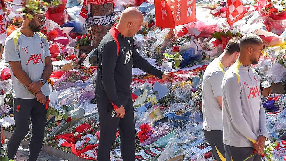 epa12232286 Liverpool head coach Arne Slot (C) lays flowers as the Liverpool team views tributes to late Portuguese soccer player Diogo Jota at Anfield, the home of Liverpool FC, in Liverpool, Britain, 11 July 2025. Jota died in a car accident in Spain together with his brother Andre Silva on 03 July 2025.  EPA/PETER POWELL