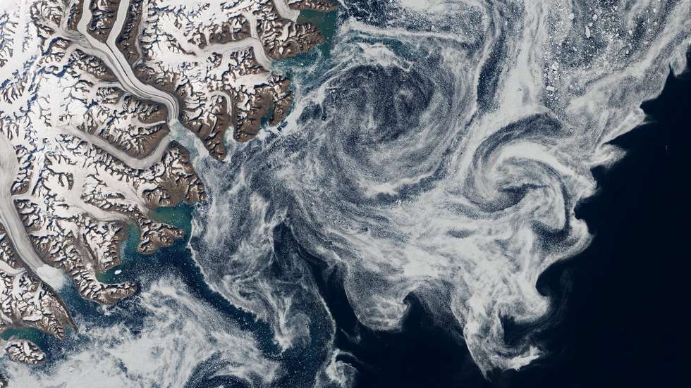 epa08560270 A handout satellite image made available by the National Aeronautics and Space Administration (NASA) shows sea ice south of the Scoresby Sound (Kangertittivaq) fjord system along the Denmark Strait, on the eastern coast of Greenland, 03 July 2020 (issued 22 July 2020). The ice in picture had drifted more than 1,000km from the Arctic Ocean, NASA reported. Arctic sea ice is subject to some serious travel restrictions. Penned in by major land masses, most ice that forms in the Arctic Ocean stays there for the duration of its existence -- typically one to four years before melting. Some ice, however, escapes the Arctic Ocean through a handful of passages and then drifts south.  EPA/NASA HANDOUT  HANDOUT EDITORIAL USE ONLY/NO SALES