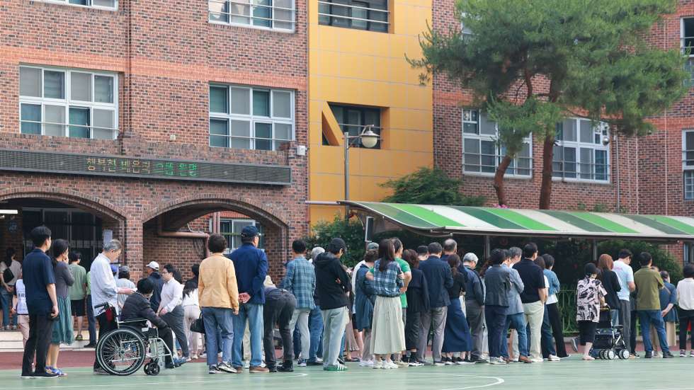 epa12151696 Voters wait in line to cast their ballots in the presidential election at an elementary school used as a polling station in Seoul's Seocho Ward, South Korea, on 03 June 2025. South Korea holds its presidential election on 03 June 2025.  EPA/YONHAP SOUTH KOREA OUT