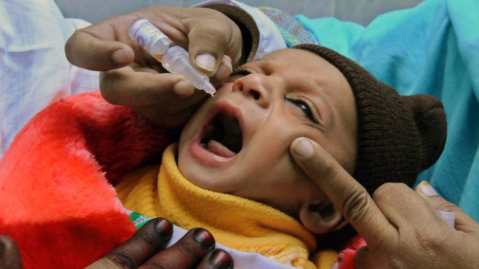 epa03513016 A female health worker gives polio vaccines to a child during a three-day nationwide vaccination campaign in Peshawar, Pakistan, 18 December 2012. Unknown armed men on 18 December killed four female workers who were on a three-day polio vaccination campaign funded by the UNICEF in Karachi. Polio is endemic in Pakistan where local religious clerics and pro-Taliban lobby are reportedly trying to convince residents that the US-manufactured polio drops were designed to sterilize Pakistanis and reduce the Muslim population.  EPA/BILAWAL ARBAB