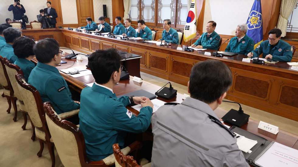 epa11165410 South Korean Prime Minister Han Duck-soo (4-R, rear) presides over a meeting of ministers at the government complex in Seoul, South Korea, 19 February 2024, to deal with a looming doctors' collective action. Han said the government will fully expand telemedicine services if doctors walk off their jobs in protest of the government's plan to increase medical school admissions.  EPA/YONHAP SOUTH KOREA OUT