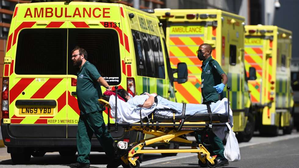 epa09359627 Ambulance staff with a patient outside the Royal London hospital in London, Britain, 23 July 2021. Covid-19 cases are continuing to sour in the UK despite England's so called 'freedom day' July 19, when total Covid-19 restrictions were lifted. Figures show that over forty thousand people are catching Covid each day with the numbers of deaths rising steadily.  EPA/ANDY RAIN