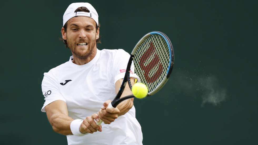 epa10038519 Joao Sousa of Portugal hits a backhand in the men's first round match against Richard Gasquet of France at the Wimbledon Championships, in Wimbledon, Britain, 28 June 2022.  EPA/TOLGA AKMEN   EDITORIAL USE ONLY