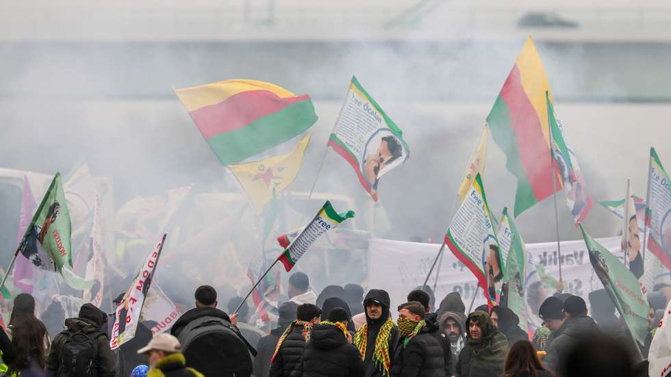 epa12511719 Protesters hold flags bearing photos of imprisoned Kurdistan Workers' Party (PKK) leader Abdullah Ocalan during a demonstration calling for his freedom in Cologne, Germany, 08 November 2025.  EPA/RONALD WITTEK