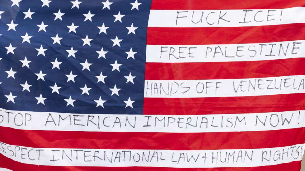epa12653190 The US flag is seen during a demonstration outside the US Embassy in solidarity with the people of Venezuela, in Johannesburg, South Africa, 16 January 2026. Added to their call not to get politically involved in the affairs of Venezuela, they also called for the freedom of Palestine.  EPA/Kim Ludbrook