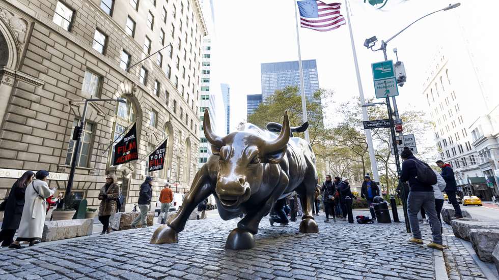 epa07981927 People walk past the 'Charging Bull' statue in the Bowling Green area of New York, New York, USA, 08 November 2019. The city is planning on moving the statue, which is a popular tourist attraction, from its current location on an island between two streets to a new site near the New York Stock Exchange.  EPA/JUSTIN LANE