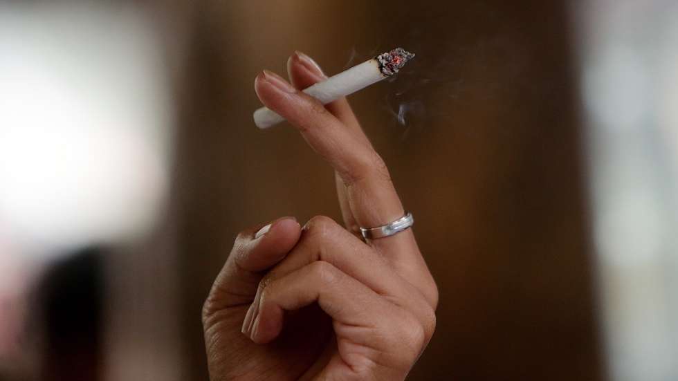 epa10379028 A man smokes a cigarette at a street in Jakarta, Indonesia, 27 December 2022. Indonesian President Joko Widodo has issued Presidential Decree of the Republic of Indonesia concerning the 202 government regulation drafting program, one of them is to stipulate a ban on the sale of cigarette sticks, on the restriction of addictive substances in tobacco products for health.  EPA/ADI WEDA