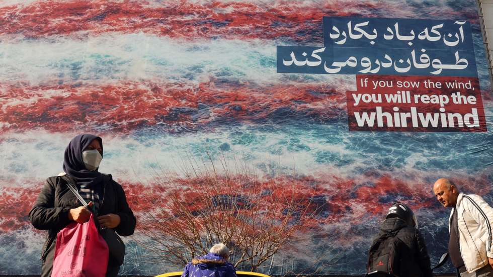 epa12684289 Iranians walk near a huge anti-US billboard hanging at the Enqelab square in Tehran, Iran, 27 January 2026. The US President Donald Trump renewed threats of military action against Iran following anti-government protests. Iran is experiencing a nationwide internet blackout that began on 08 January 2026, amid an intensifying wave of anti-government protests.  EPA/ABEDIN TAHERKENAREH