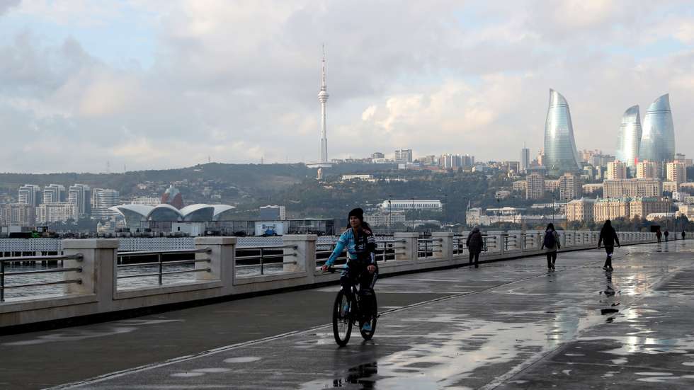 epa11711240 People along the promenade with the Baku TV Tower (C) and the Flame Towers (R) seen in the background, in Baku, Azerbaijan, 09 November 2024. The Azerbaijani capital of Baku will host the 2024 United Nations Climate Change Conference (COP29) from 11 to 22 November 2024.  EPA/IGOR KOVALENKO