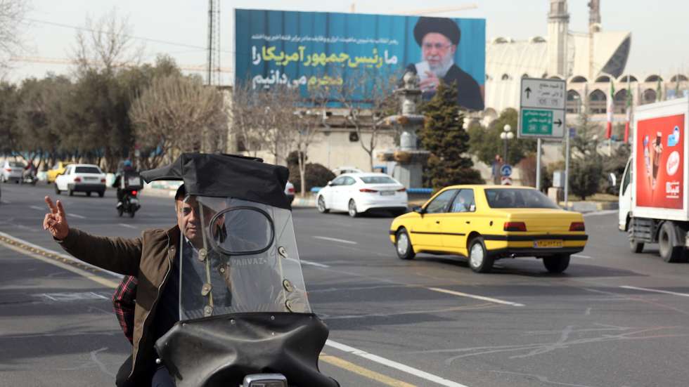 epaselect epa12699968 An Iranian man flashes victory sign as drive past next to a picture of Iranian supreme leader Ayatollah Ali Khamenei in a street in Tehran, Iran, 02 February 2026. Following the US President Donald Trump renewed threats of military action against Iran, Iranian supreme leader Ayatollah Ali Khamenei on 01 February 2026 warned that any military attack by the United States would spark a 'regional war'.  EPA/ABEDIN TAHERKENAREH