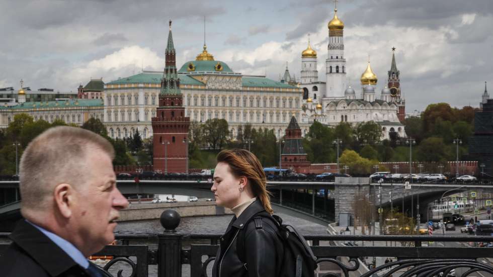 epa09944773 Russian people walk in front of the Kremlin in Moscow, Russia, 13 May 2022.  EPA/YURI KOCHETKOV