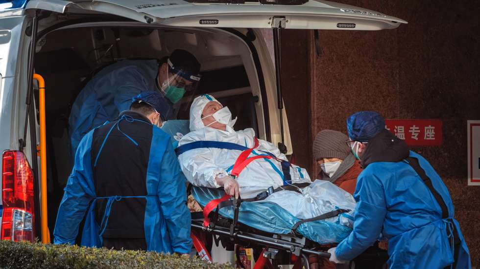 epa10376986 Health workers carry a person to the hospital, in Shanghai, China, 23 December 2022. Hospitals in China struggle to cope due to the rising number of COVID-19 cases. Since the abrupt lifting of domestic COVID-19 restrictions, cases have rocketed in China, causing businesses to close because employees are sick, schools are shifting to online classes, and pharmacies are struggling with the high demand. On 21 December, Shanghai Deji Hospital’s official WeChat account published a post with an estimated 5.43 million positive cases in the city and predicted that 12.5 million could get infected by the end of the year. The day after, the post was no longer available.  EPA/ALEX PLAVEVSKI