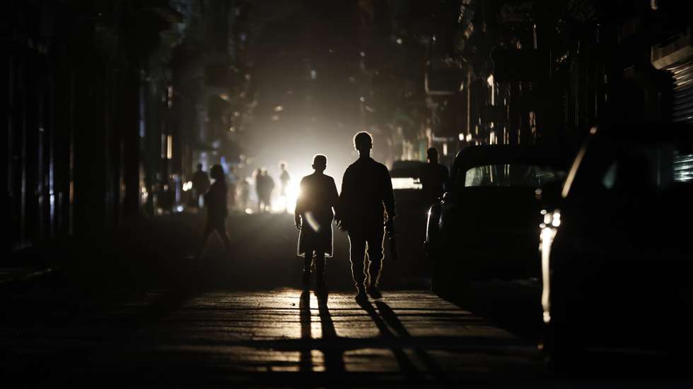 epaselect epa12840313 People walk down a street during a national power outage, in Havana, Cuba, 21 March 2026. Cuba experienced another nationwide blackout due to a total shutdown of the National Electric System (SEN) at 6:38 p.m. local time (10:38 p.m. GMT), the second in less than a week and the seventh in a year and a half.  EPA/Ernesto Mastrascusa