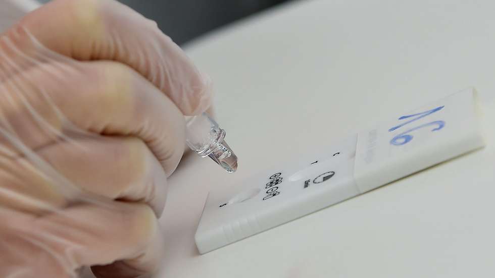 epa08900905 A health workers performs a rapid coronavirus disease (COVID-19) antigen test on a swab sample, for health workers and guests of the Cottolengo hospital, organized by the association 'Camminare insieme' (walking together), in Turin, northern Italy, 23 December 2020.  EPA/ALESSANDRO DI MARCO
