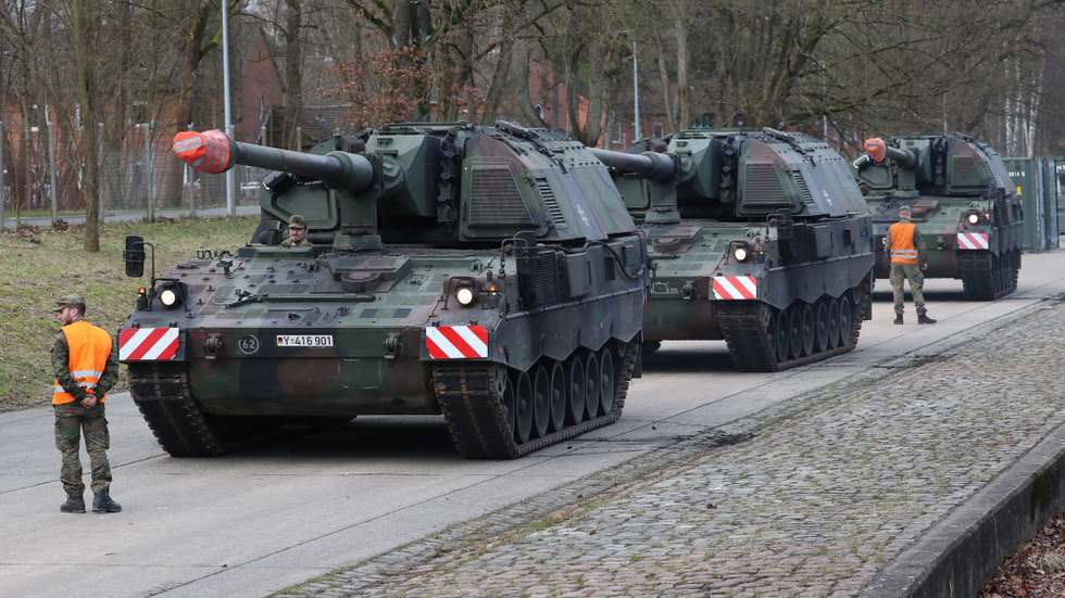 epa09755477 Self-propelled howitzers type Panzerhaubitze PzH 2000 of the German Army wait to be loaded onto trucks at the Hindenburg barracks in Munster, northern Germany, 14 February 2022. The German Artillerielehr Battalion 325 will send six of its cannons to Lithuania where 350 additional soldiers with about 100 vehicles will reinforce the German troops taking part in the  NATO mission Enhanced Forward Presence (EFP).  EPA/FOCKE STRANGMANN