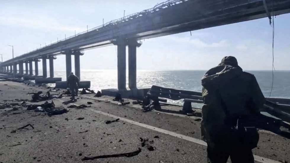 epa10230386 A still image taken from handout video provided by the Russian Investigative committee shows Russian investigators work on a collapsed part of the Kerch Strait bridge in Crimea, 08 October 2022. According to Russian authorities, "an explosion was set off at a cargo vehicle on the motorway part of the Crimean bridge on the side of the Taman peninsula, which set fire to seven fuel tanks of a train that was en route to the Crimean peninsula. Two motorway sections of the bridge partially collapsed."  EPA/RUSSIAN INVESTIGATIVE COMMITEE HANDOUT  HANDOUT EDITORIAL USE ONLY/NO SALES