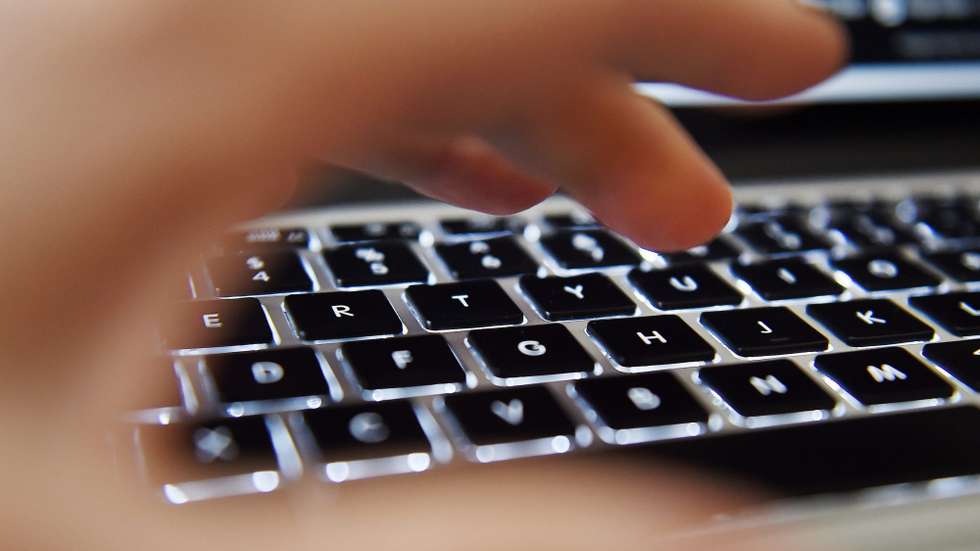 Uma mão sobre o teclado de um computador portátil