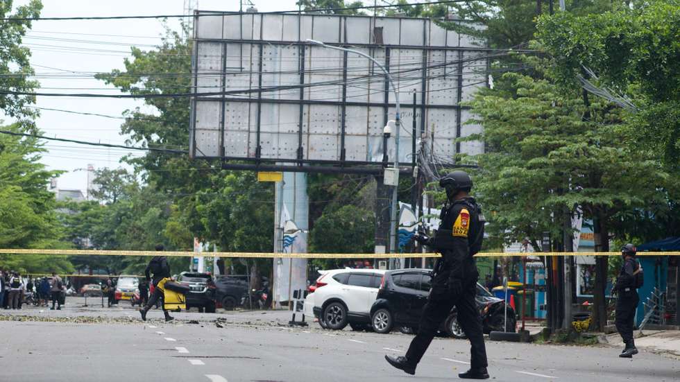 epa09102556 Police counter-terrorism squad members cordon off the area surrounding the Sacred Heart of Jesus Cathedral in the aftermath of an explosion, in Makassar, South Sulawesi, Indonesia, 28 March 2021. At least nine people were wounded as a suspected suicide bomber blew themselves up outside the church on Palm Sunday. The number of casualties was still unclear.  EPA/IQBAL LUBIS