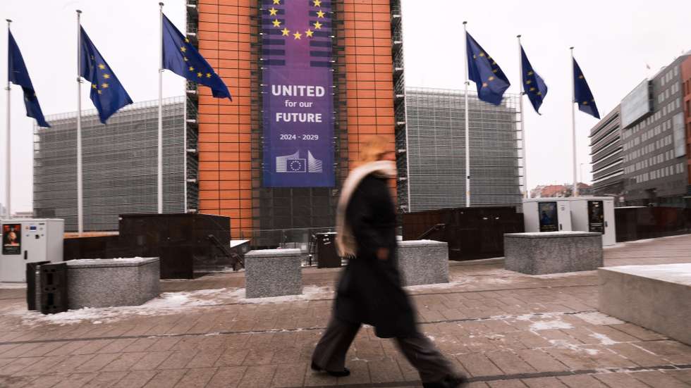 epa12628728 People walk in front of the Berlaymont building, the headquarters of the European Commission, with a sign reading 'United for our Future' on a winter day in Brussels, Belgium, 05 January 2026.  EPA/OLIVIER HOSLET