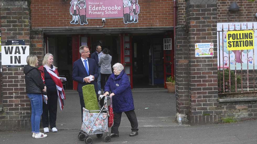 epa09928389 Alderman Brian Kingston of The DUP [Democratic Unionist Party] (C) outside the polling station at Edenbrooke Primary School in Belfast, Northern Ireland, 05 May 2022.  Polling stations across Northern Ireland are open for voting for the 2022 Assembly Election.  EPA/MARK MARLOW