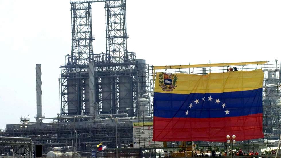 epa01253615 (FILE) A file picture dated 01 May 2007 shows Venezuelan workers as they suspend a giant flag in front of the Jose Petrochemical plant in Barcelona, Venezuela. Venezuela's state oil company PDVSA has announced it is suspending sales of crude to Exxon Mobil, in response to legal action brought by the US firm, reports said on 12 February 2008. Hugo Chavez has said he will no longer do business with Exxon which he says is not welcome in Venezuela.  EPA/CHICO SANCHEZ