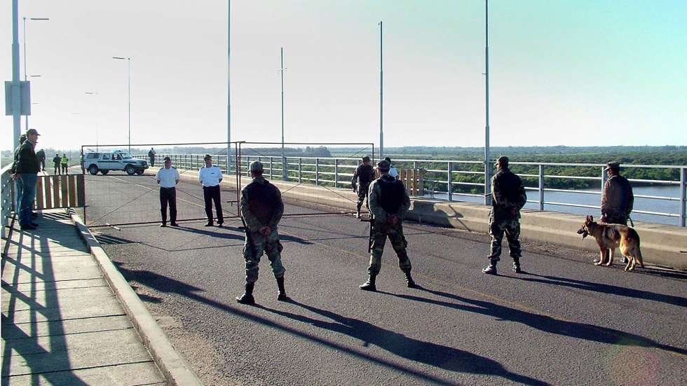epa01182833 Uruguay´s police force members block  the 'General Artigas' bridge which connects the Uruguayan city of Paysandu with the Argentinian Colon after a closing order of the three international border bridges between the two countries was pronounced by the Government of Uruguay, 25 November 2007. With this measure in the south of the country lUruguay hopes to stop a protest by members of the Gualeguaychu Enviromental Assembly against the Finnish Botnia cellulose factory.  EPA/ANDRES SANCHEZ