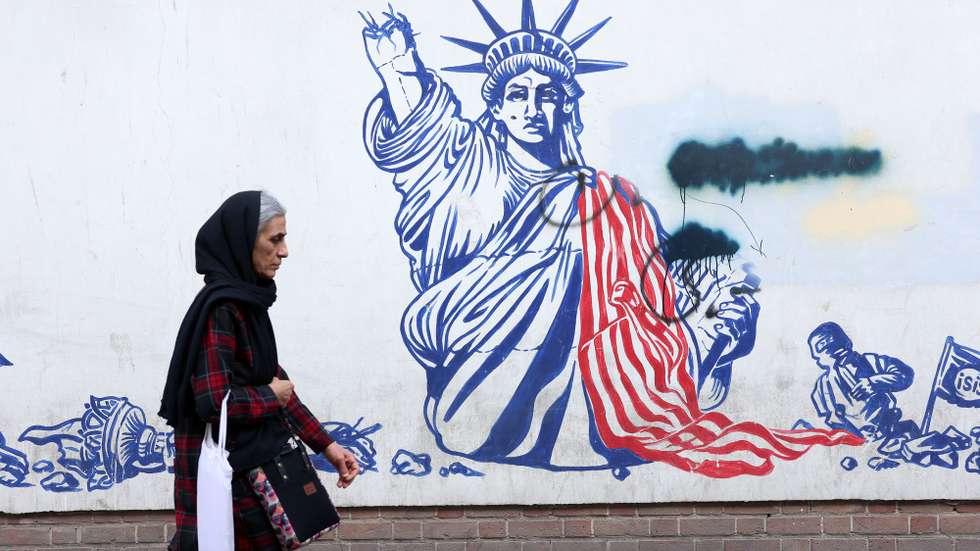 epa12770848 An elderly Iranian woman walks next to an anti-US mural in Tehran, Iran, 23 February 2026. According to a statement by the Omani Foreign Minister on X (formerly Twitter), Iran and the US are expected to hold another round of talks on 26 February 2026 in Geneva, Switzerland, to resume nuclear negotiations.  EPA/ABEDIN TAHERKENAREH