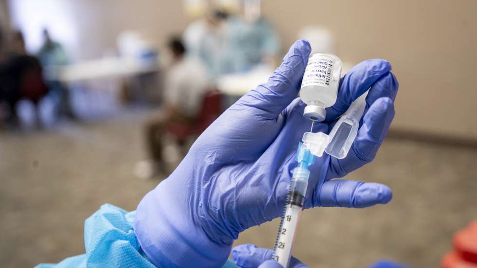 epa08746318 A nurse draws flu vaccine from a vial at a free mobile clinic in Lakewood, California, USA, 14 October 2020. Flu vaccine manufacturers have increased production in anticipation of this year's flu season.  EPA/ETIENNE LAURENT