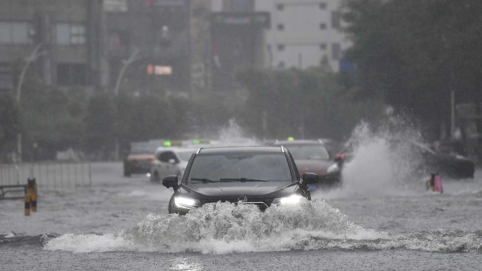 epa12249767 Vehicles drive through a flooded area in Haikou, Hainan Province, China, 20 July 2025. Typhoon Wipha, the sixth typhoon of the year, made landfall near Jiangmen City in south China's Guangdong Province around 5:50 p.m., according to the Guangdong provincial meteorological observatory. Hainan raised its emergency response for flood and typhoon control from Level IV to Level III, as strong winds and rainstorms are expected to impact the island province.  EPA/XINHUA / Yang Guanyu CHINA OUT / UK AND IRELAND OUT  /       MANDATORY CREDIT EDITORIAL USE ONLY