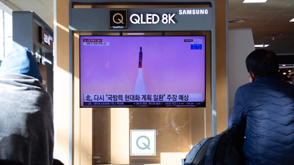 Pessoas a ver as notícias na Coreia do Sul