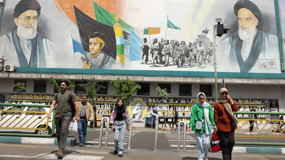 epa12017452 Iranians walk next to huge wall painting of Iranian supreme leader Ayatollah Ali Khamenei (Top-R) and late supreme leader Ayatollah Ruhollah Khomeini (Top-L) in a street, in Tehran, Iran, 08 April 2025. Iranian Foreign Minister Abbas Araqchi said on 08 April that top Iranian and US officials will hold indirect negotiations in Oman on 12 April.  EPA/ABEDIN TAHERKENAREH