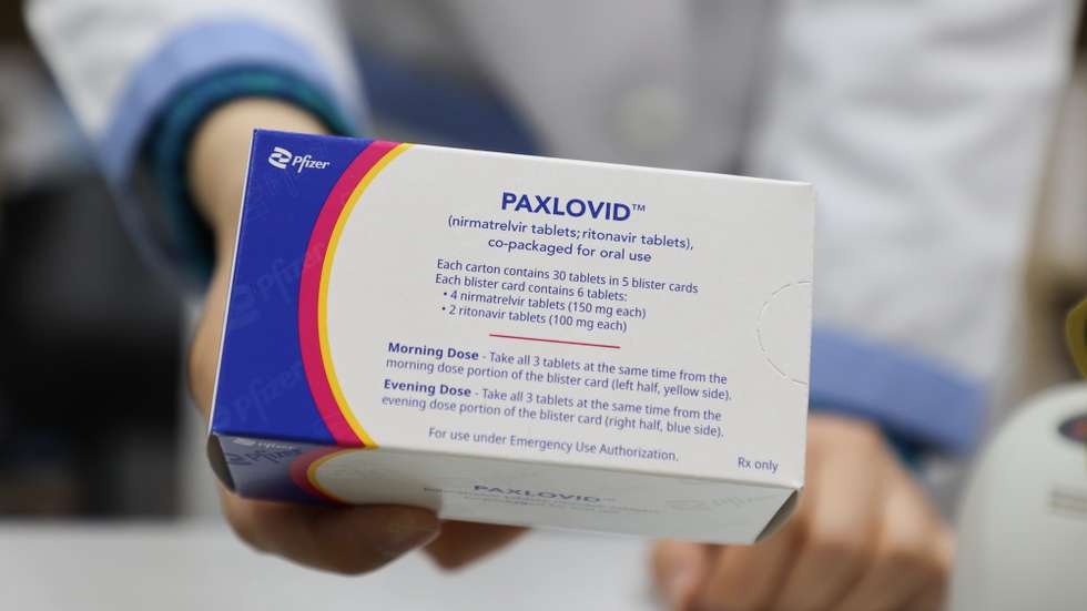 epa09775282 A pharmacist displays a case of Paxlovid, a COVID-19 treatment pills developed by Pfizer Inc., at a drugstore in Seoul, South Korea, 21 February 2022. The age restriction on the administration of the pills to those with underlying diseases was lowered to 40 from 50.  EPA/YONHAP SOUTH KOREA OUT