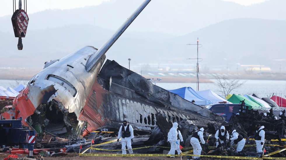 epa11799472 A police forensic team conducts an on-site investigation at the scene of the 29 December Jeju Air passenger plane crash at Muan International Airport in Muan, South Korea, 31 December 2024.  EPA/YONHAP SOUTH KOREA OUT