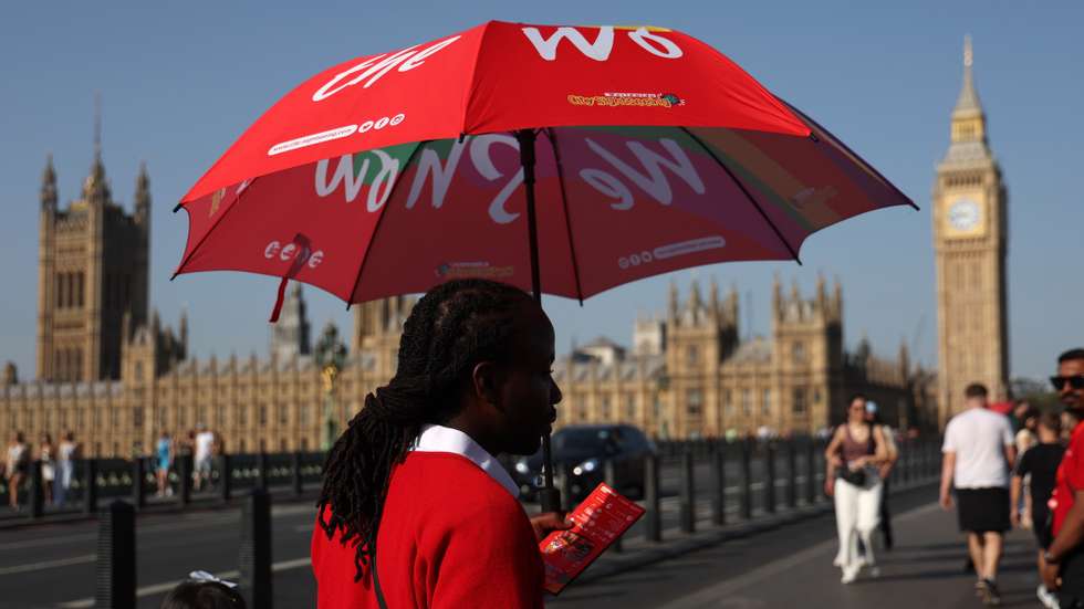 epa10850534 A tour bus employee shades himself from the sun in central London, Britain, 09 September 2023. The late Indian summer has brought the hottest day of the year to the UK with temperatures exceeding 33C.  EPA/ANDY RAIN