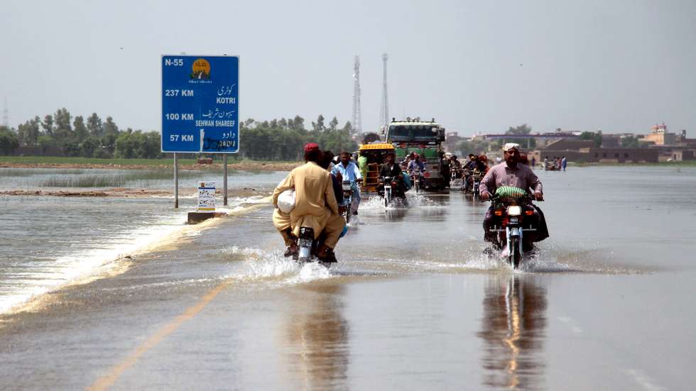 epa10147386 People cross a flooded highway in Dadu district, Sindh province, Pakistan, 30 August 2022. According to the National Disaster Management Authority (NDMA) on 27 August, flash floods triggered by heavy monsoon rains have killed over 1,000 people across Pakistan since mid-June 2022. More than 33 million people have been affected by floods, the country&#039;s climate change minister said.  EPA/WAQAR HUSSEIN