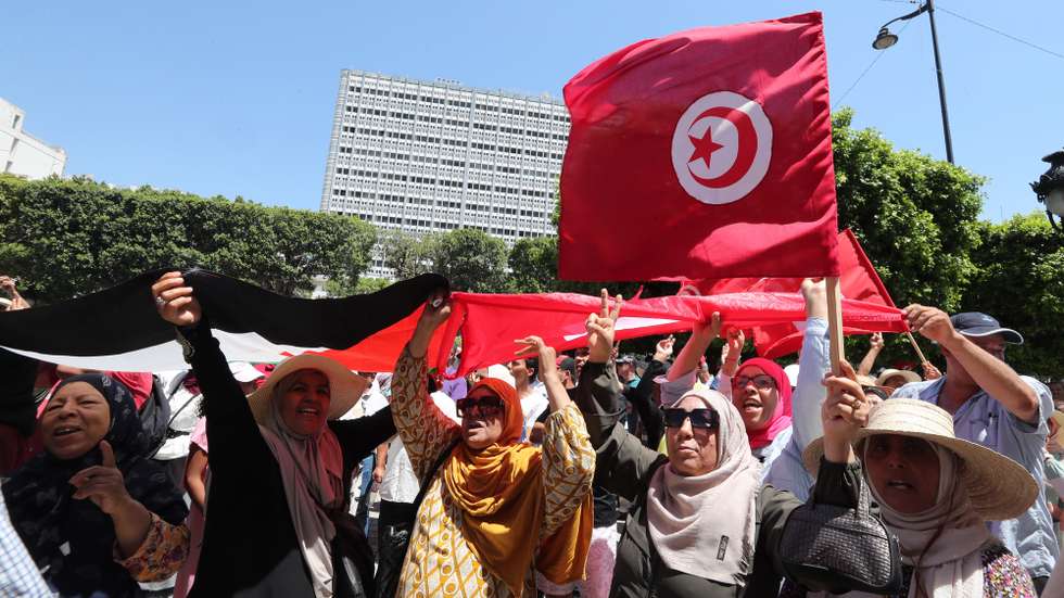 epa10021990 Tunisians shout slogans and carry Tunisian flags during a protest against Tunisian President Kais Saied and the constitutional referendum, which will be held on 25 July, in Tunis, Tunisia, 19 June 2022. The protest is organized by the 'National Salvation Front' and call on Tunisians to refuse the constitutional referendum, and all decisions issued by Tunisian President Kais Saied.  EPA/MOHAMED MESSARA