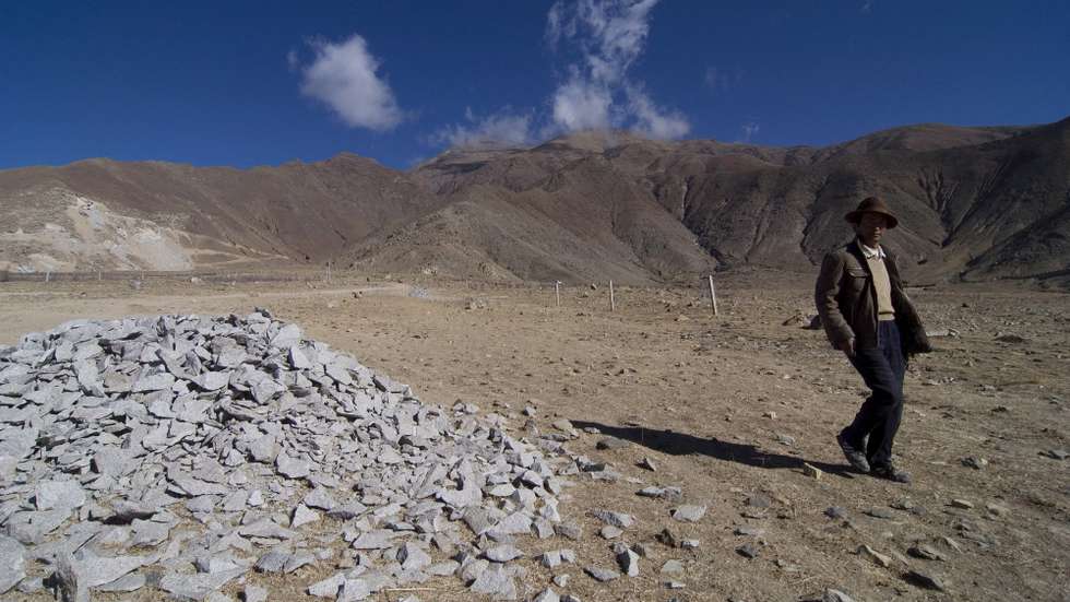 epa01681621 A Tibetan ethnic man passes by stones which were discarded from a truck of stone pit in Najin, in the rural area of Lhasa, China's Tibet, 29 March 2009. The Tibet Autonomous Region of China is located in the southwest part of the Qinghai-Tibet Plateau. It borders on Sichuan and Yunnan provinces to the east, Qinghai and Xinjiang to the north, and shares borders with India, Nepal, Sikkim, Bhutan and Burma to the south, and is bounded by Kashmir to the west.  The region covers more than 1.2 million square kilometers, accounting for one eighth of China's total land mass, and ranking second in China. Tibet has various complex landforms such as high and steep mountains, deep valleys, glaciers, bare rocks and gobi deserts. All places in the region lie at an average altitude of more than 4,000 meters. Tibet has a population of 2.61 million, 92.2 per cent of whom are Tibetans, or 2.41 million.  EPA/NG KONG