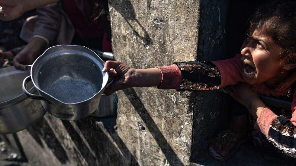 epa11756145 A displaced Palestinian child holds up an empty pot as she and others wait to receive food aid provided by a Palestinian youth group in a refugee camp in Rafah, southern Gaza Strip, 25 January 2024.  EPA/HAITHAM IMAD