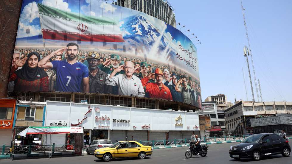 epaselect epa12190536 The traffic passes a billboard showing various Iranians including military personnel and Iranian Foreign Minister Abbas Araghchi (3-R) saluting and a message reading 'We all are soldiers of Iran' at Vali-Asr square in Tehran, Iran, 22 June 2025. The US forces struck three of Iran's key nuclear sites: Natanz, Isfahan and Fordo, US President Trump announced on 21 June. Israel and Iran have been exchanging fire since Israel launched strikes across Iran on 13 June 2025 as part of Operation 'Rising Lion.'  EPA/ABEDIN TAHERKENAREH